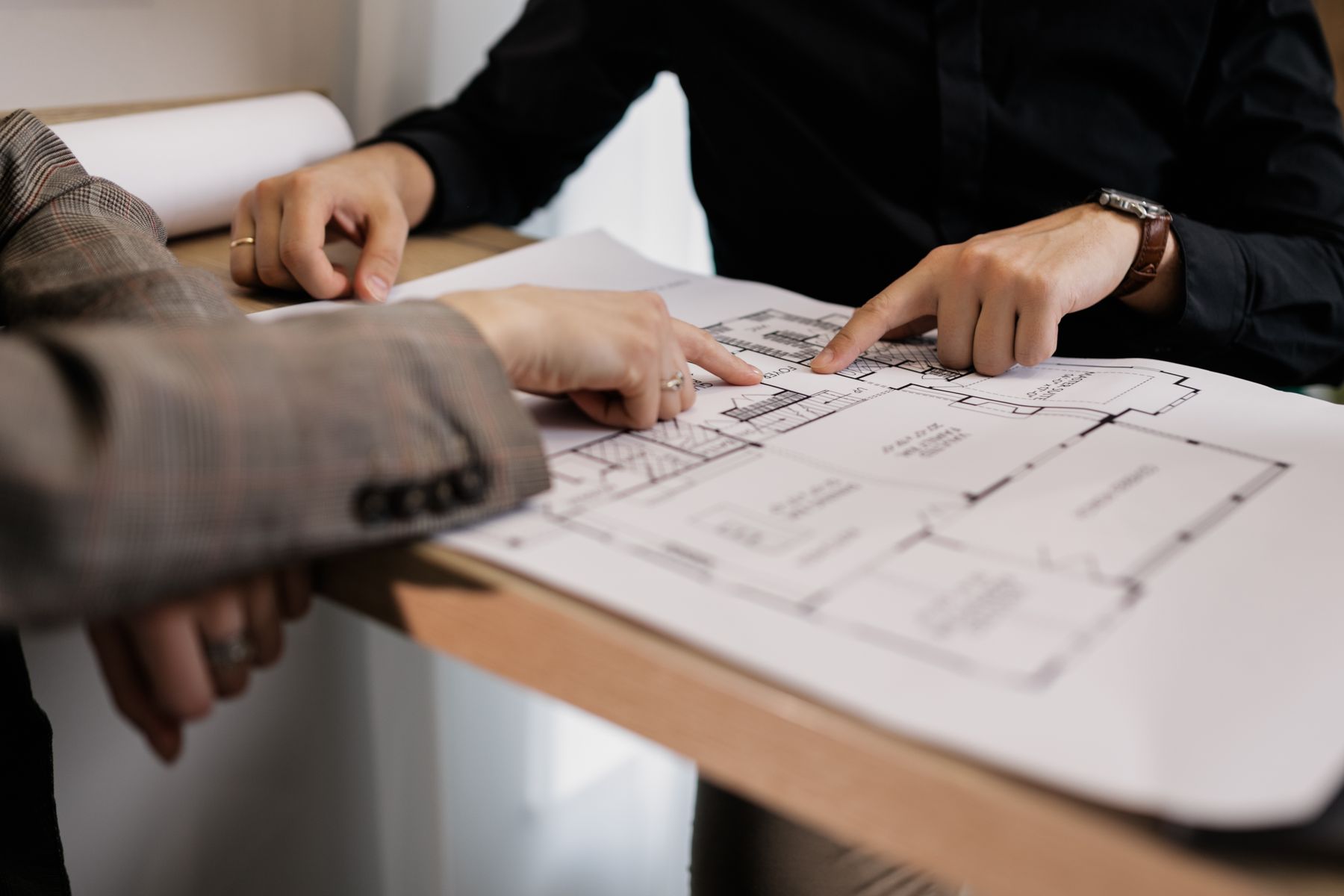 Two professionals reviewing a property floor plan together